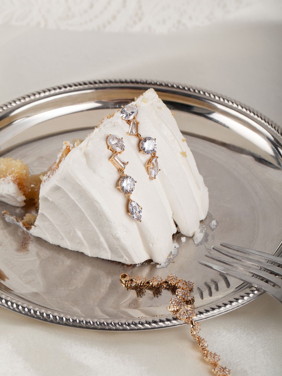 Decorative jewelry piece on a slice of cake with a silver plate