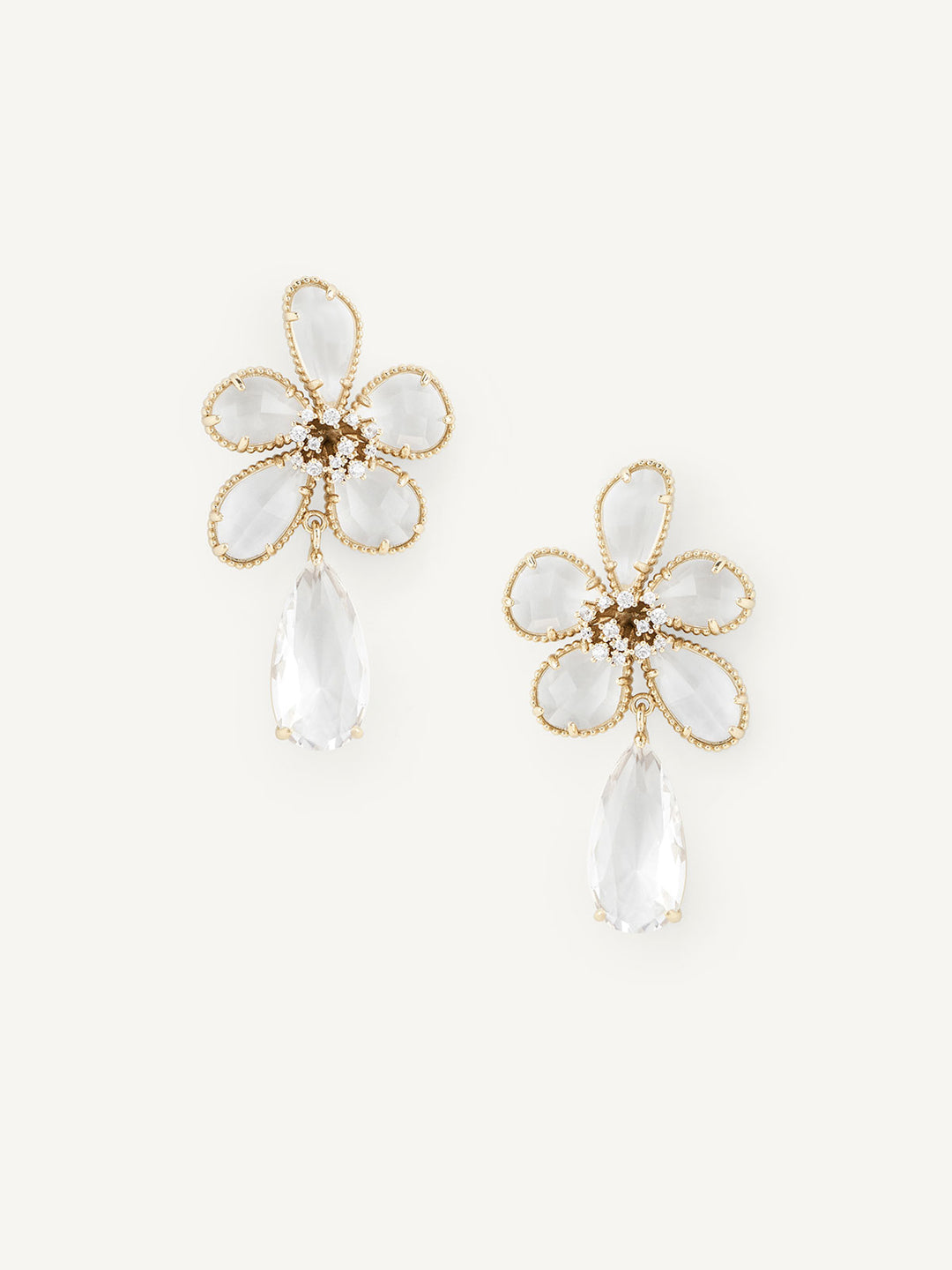 Flower-shaped earrings with gold frames and clear teardrop stones on a white background