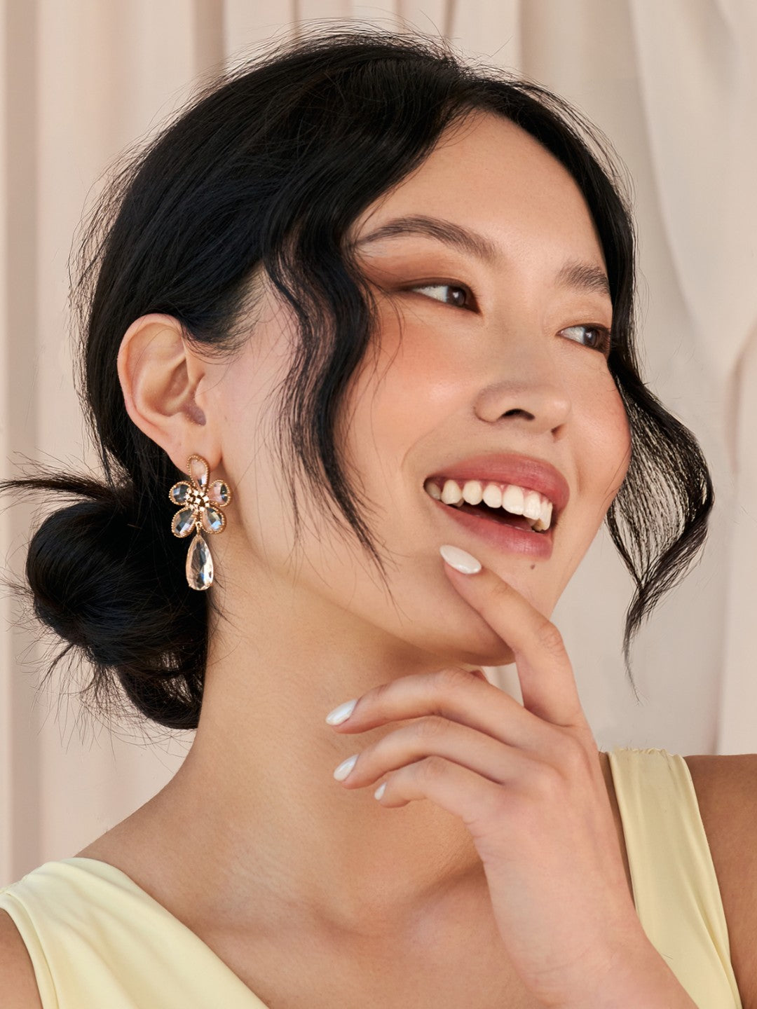 Woman wearing floral earrings with a neutral background