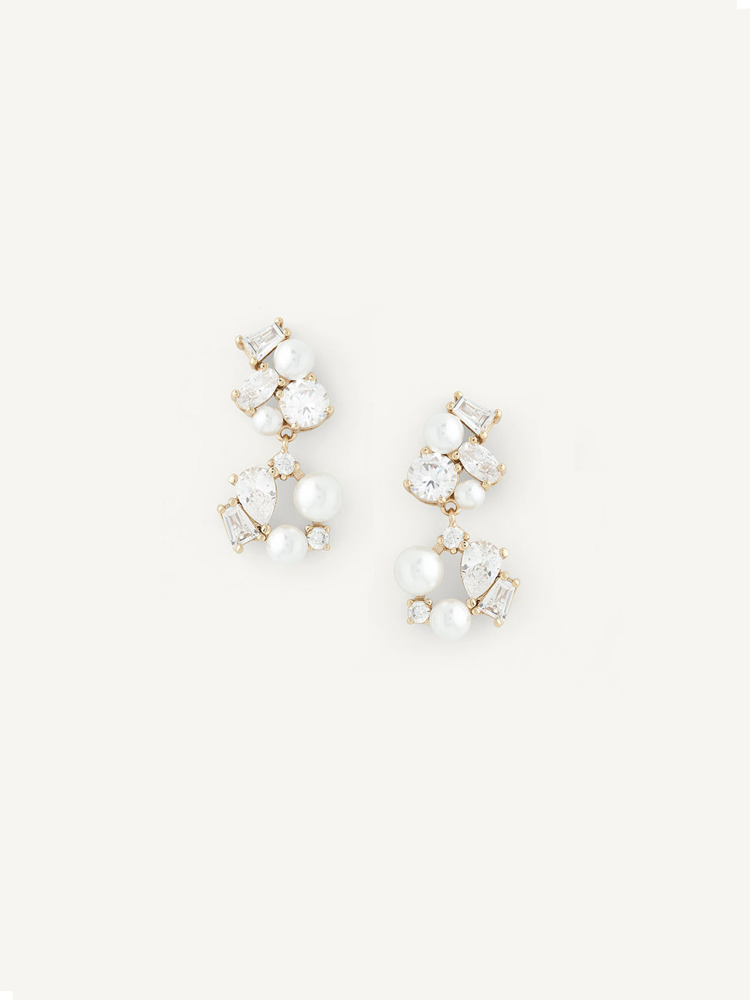 Gold pair of pearl earrings on a white background