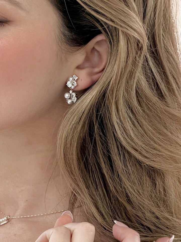 Close-up of a woman wearing gold earrings with a blurred background