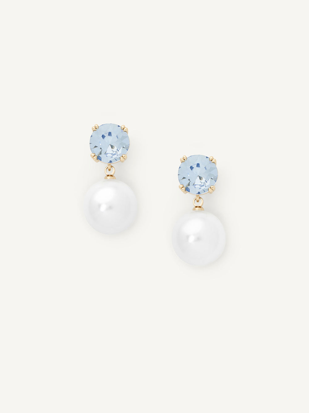 Pair of earrings with pearl-like stones and blue gemstones on a white background