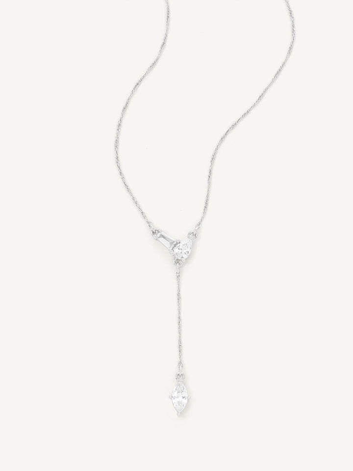 Silver necklace with a heart-shaped pendant on a light gray background