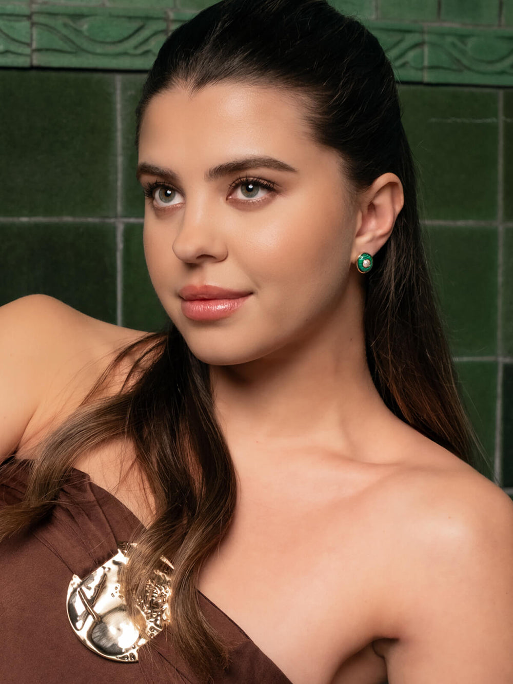 Woman stud earrings with green and gold gemstones