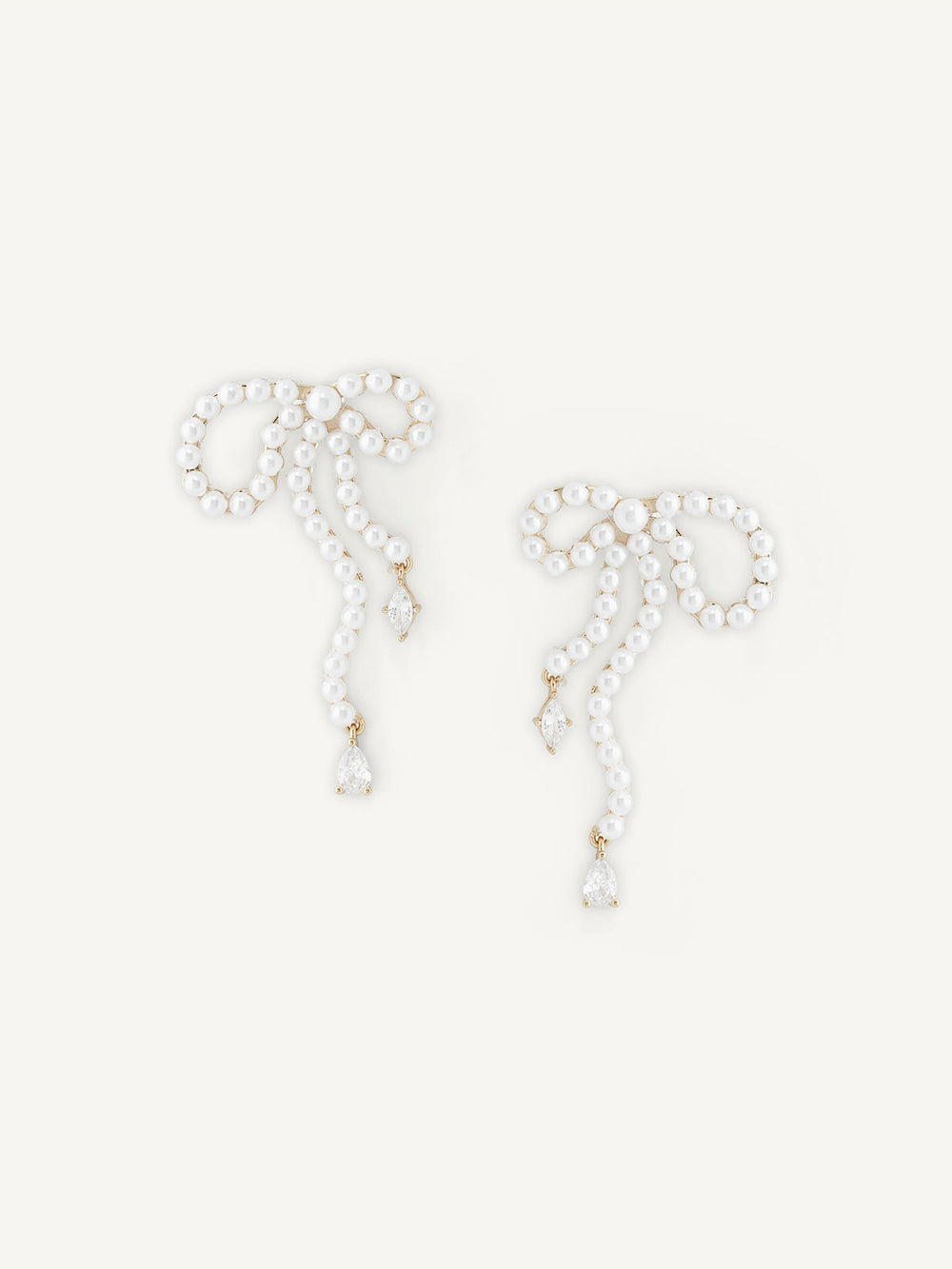 Pair of pearl bow earrings on a white background