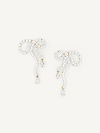 Pair of pearl bow earrings on a white background