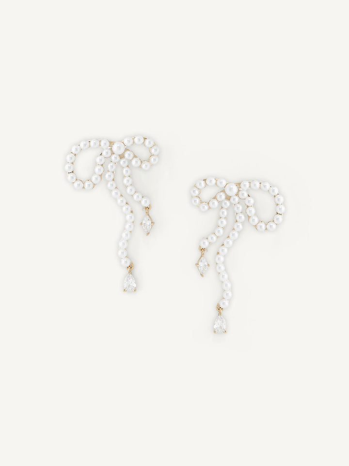 Pair of pearl bow earrings on a white background