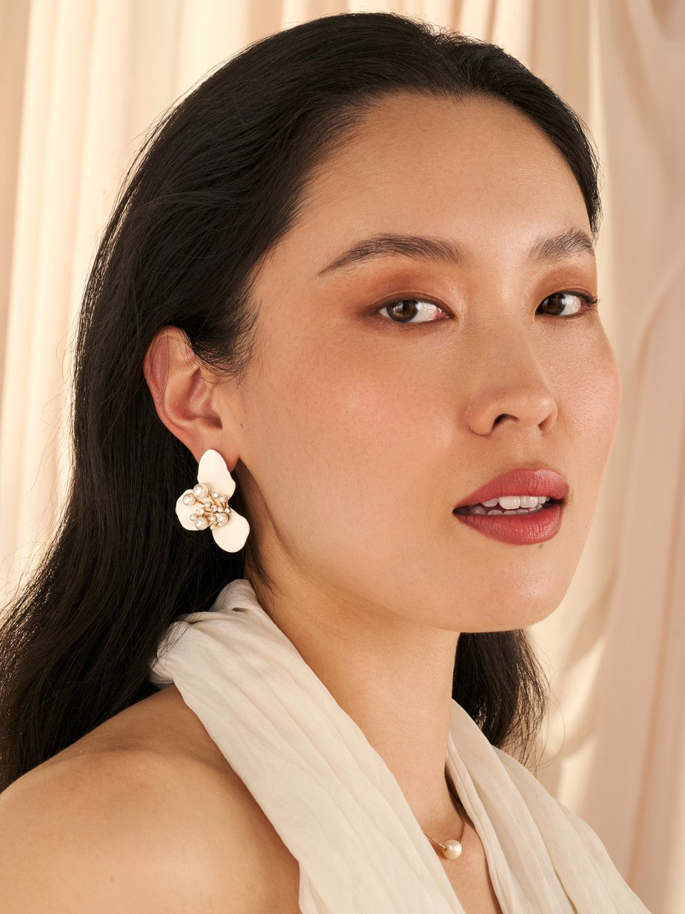 Woman wearing a floral earring with a soft background