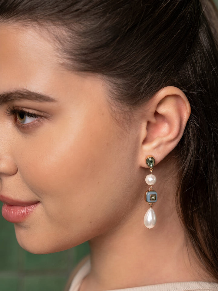 Close-up of a woman wearing Olive and Piper earrings with pearls and gemstones.